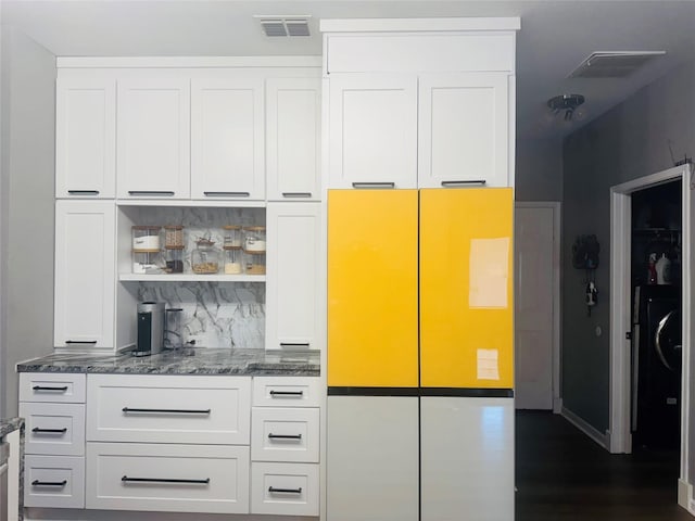 interior space with dark stone counters and white cabinets