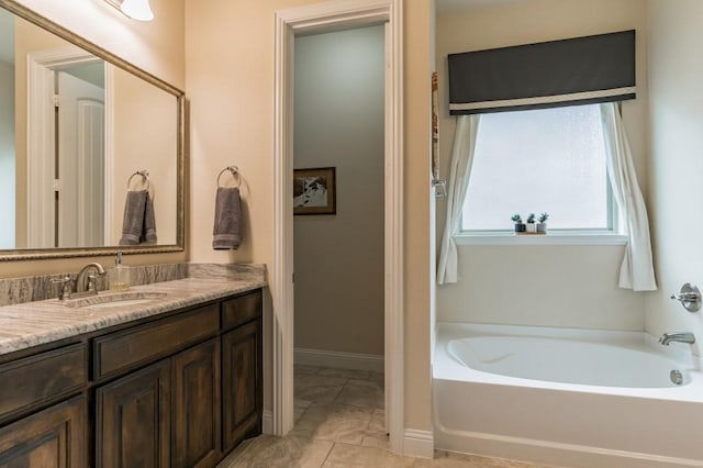 bathroom with tile patterned flooring, a bathing tub, and vanity