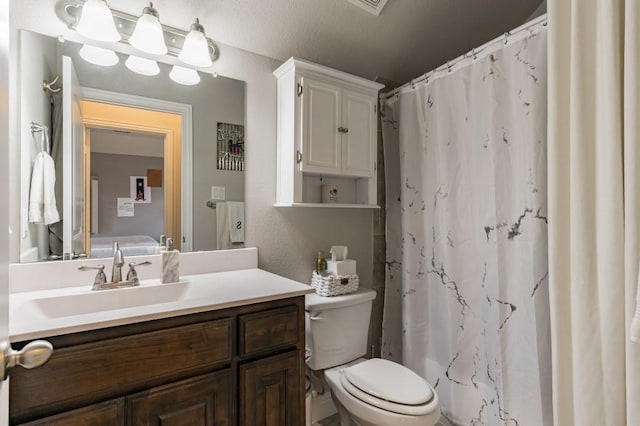 bathroom with vanity, toilet, and walk in shower