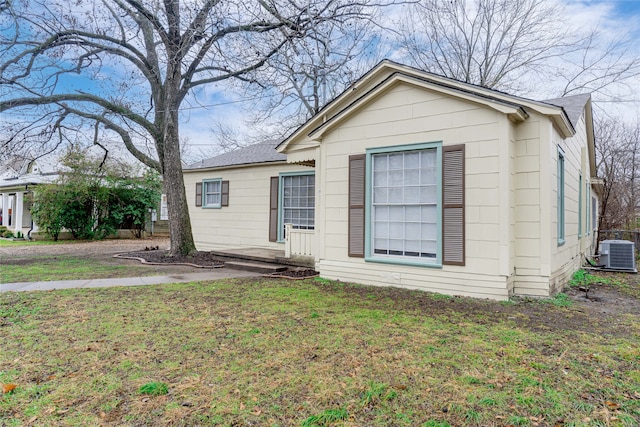 view of front of home with central AC and a front yard