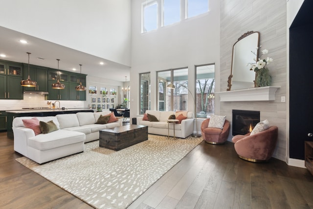 living area with dark wood finished floors, recessed lighting, and a tile fireplace