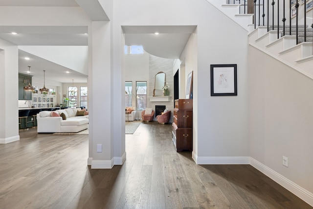 foyer entrance featuring hardwood / wood-style floors and a towering ceiling