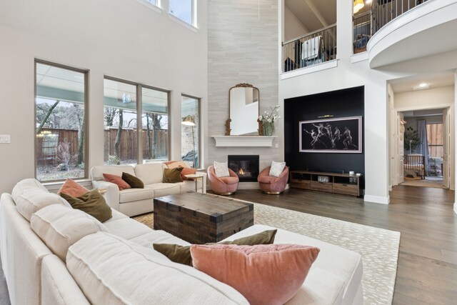 living room featuring an inviting chandelier, dark hardwood / wood-style flooring, and a tile fireplace