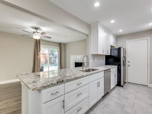 kitchen with sink, stainless steel dishwasher, kitchen peninsula, and white cabinets