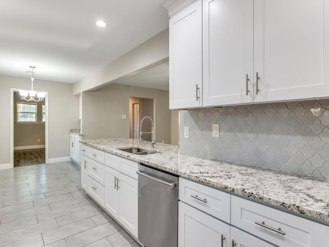 kitchen with white cabinetry, stainless steel dishwasher, light stone countertops, and sink