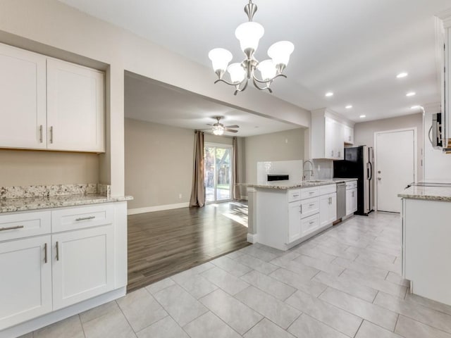 kitchen featuring pendant lighting, stainless steel dishwasher, and white cabinets