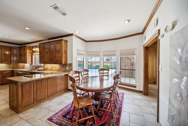 dining space with crown molding and sink