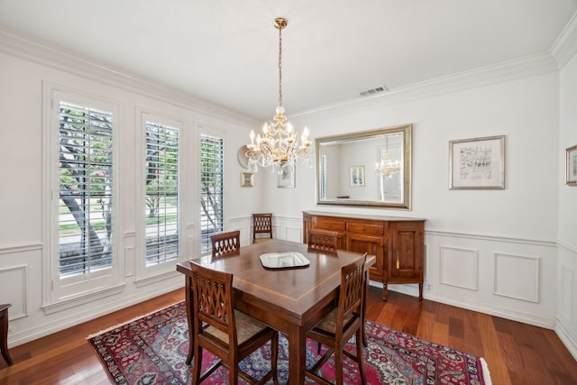 dining room with ornamental molding, a chandelier, and dark hardwood / wood-style flooring