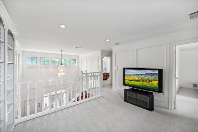 unfurnished living room featuring ornamental molding, a chandelier, and light carpet