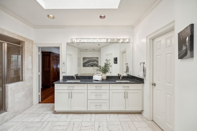 bathroom featuring vanity, crown molding, a skylight, and a shower with shower door