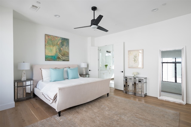 bedroom featuring hardwood / wood-style floors, ensuite bath, and ceiling fan