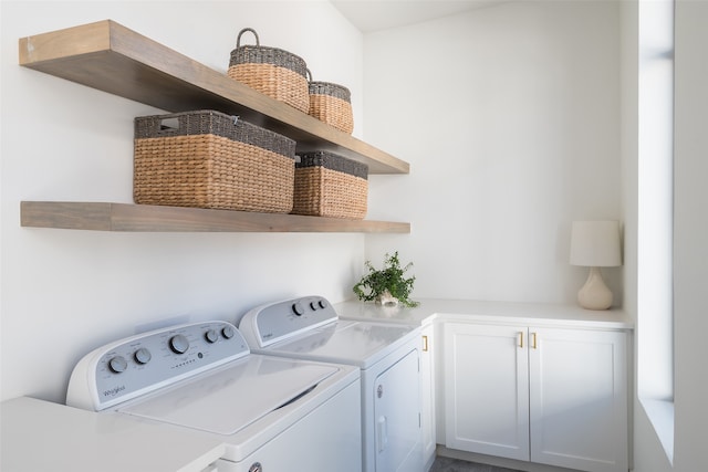 clothes washing area with cabinets and washer and dryer