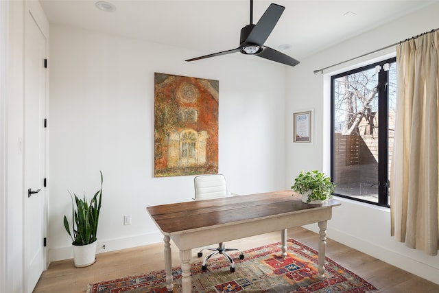 office with ceiling fan and light hardwood / wood-style floors