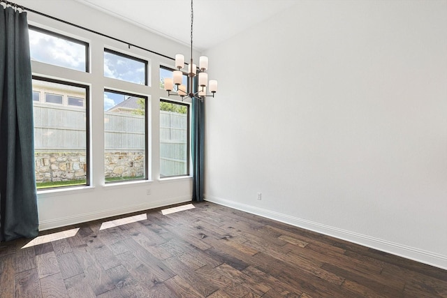 unfurnished dining area featuring dark hardwood / wood-style flooring and an inviting chandelier