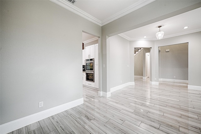 spare room with ornamental molding and light hardwood / wood-style flooring