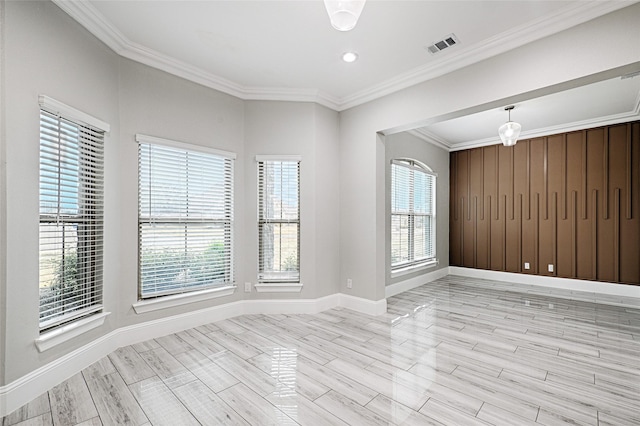 unfurnished room featuring ornamental molding and light wood-type flooring