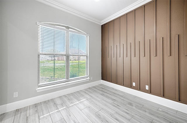 spare room featuring crown molding and light hardwood / wood-style flooring