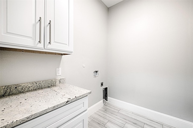 laundry room featuring electric dryer hookup and cabinets