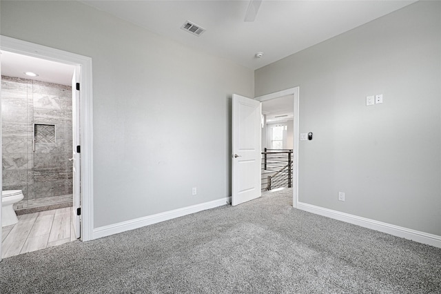 unfurnished bedroom with connected bathroom and carpet flooring