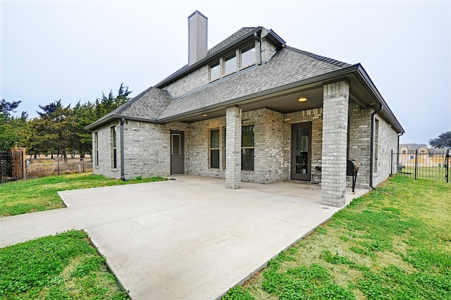 rear view of property with a yard and a patio area