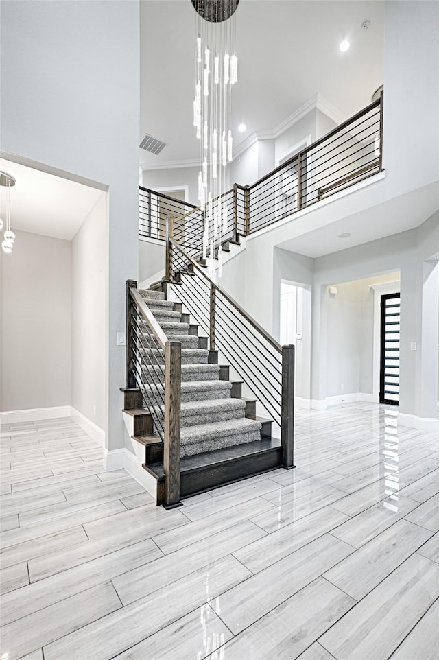 staircase featuring a towering ceiling and a chandelier