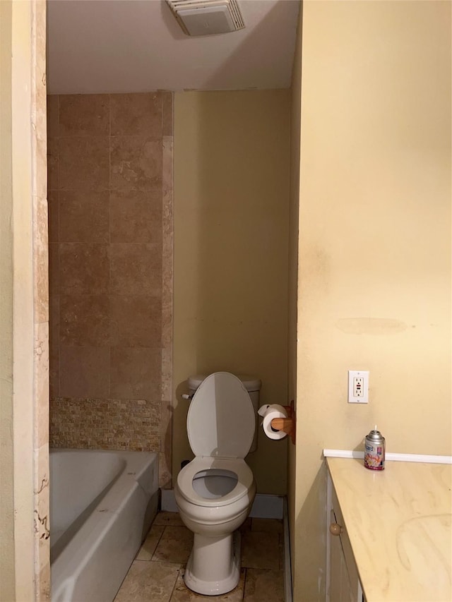 bathroom featuring vanity, tile patterned floors, a bathing tub, and toilet