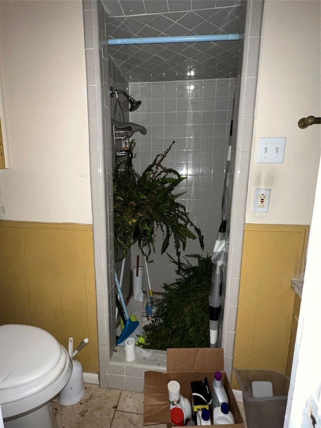 bathroom featuring tile patterned floors, toilet, and tiled shower