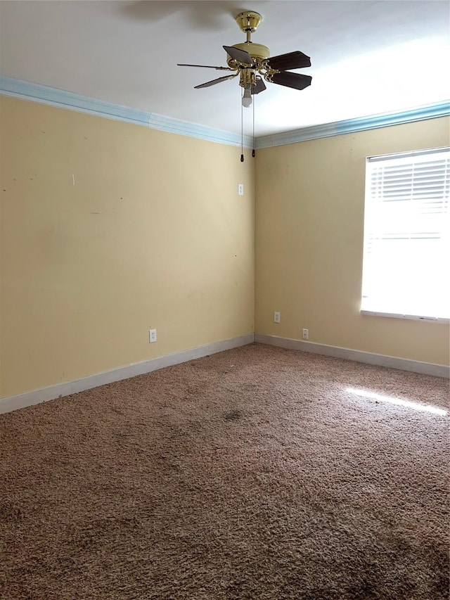 carpeted spare room featuring crown molding and ceiling fan