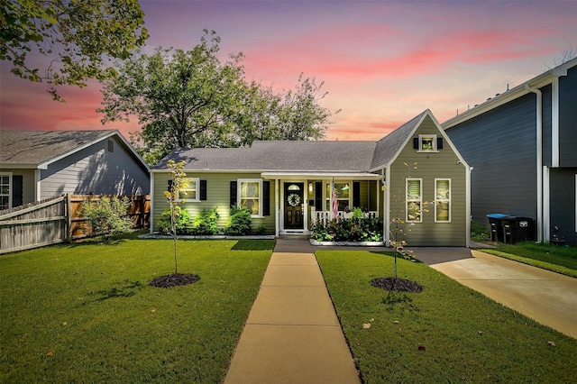 view of front of home with covered porch and a lawn