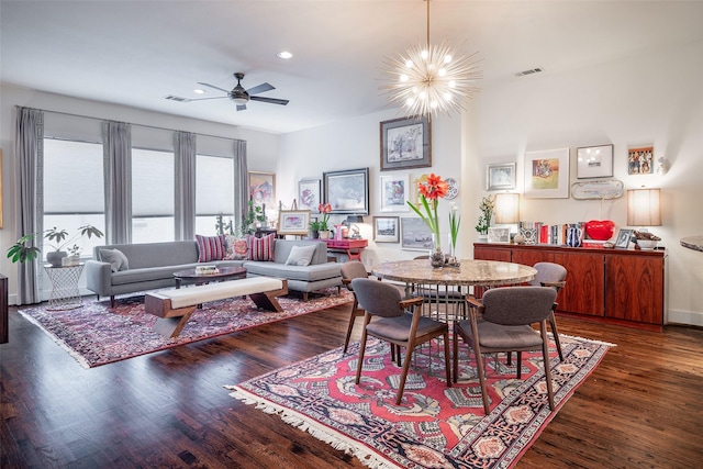 dining area with dark hardwood / wood-style flooring and ceiling fan with notable chandelier