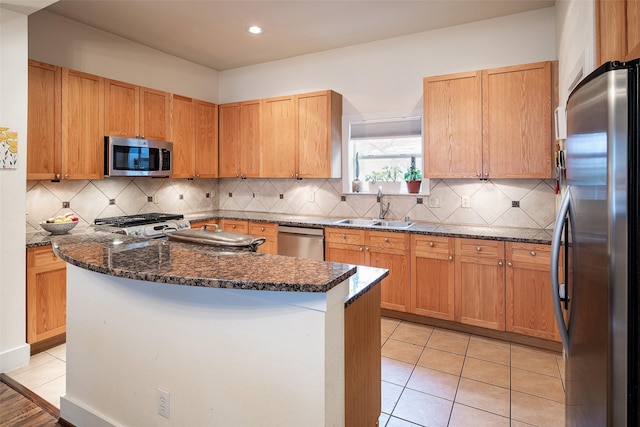 kitchen with tasteful backsplash, sink, dark stone countertops, light tile patterned floors, and stainless steel appliances