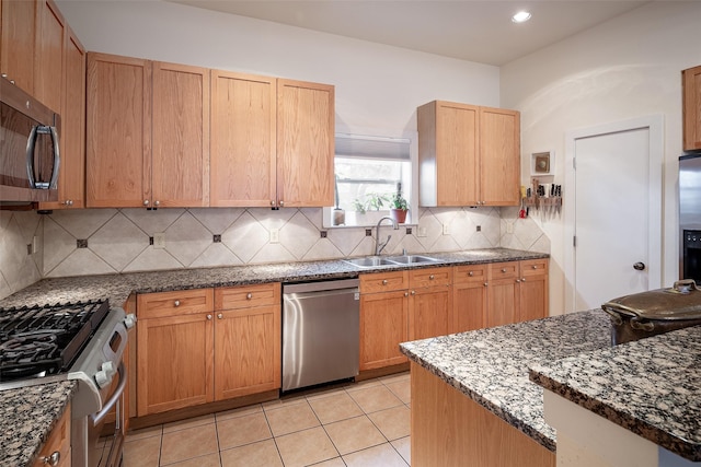 kitchen featuring sink, light tile patterned floors, dark stone counters, stainless steel appliances, and backsplash