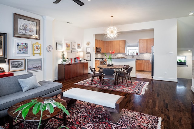 living room with hardwood / wood-style floors and ceiling fan with notable chandelier