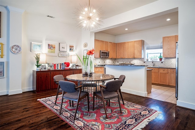 dining space featuring wood-type flooring and a notable chandelier