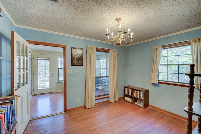 foyer with a notable chandelier, wood-type flooring, and a wealth of natural light