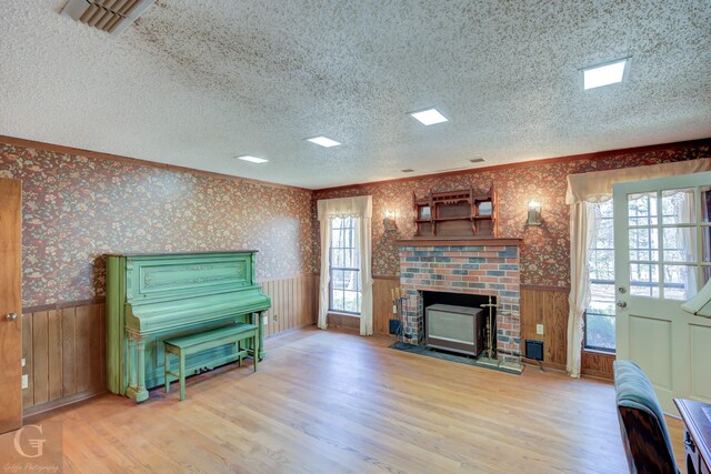 miscellaneous room featuring ornamental molding, a wealth of natural light, a textured ceiling, and light wood-type flooring