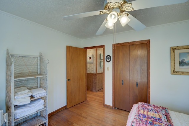 bedroom featuring ceiling fan, a textured ceiling, light wood-type flooring, and a closet