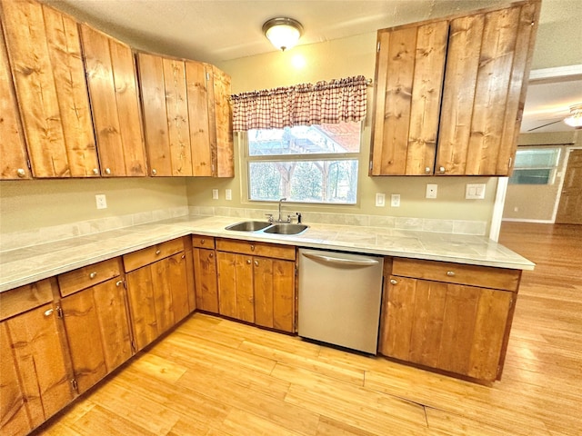 kitchen with sink, stainless steel dishwasher, and light hardwood / wood-style floors