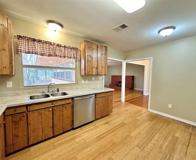 kitchen featuring sink, light hardwood / wood-style flooring, and stainless steel dishwasher