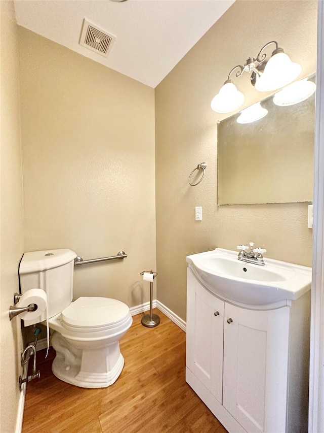 bathroom with vanity, hardwood / wood-style floors, and toilet