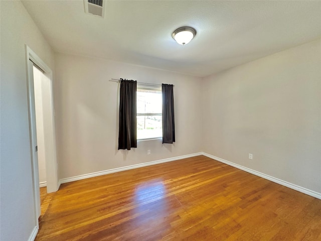 unfurnished room featuring hardwood / wood-style flooring