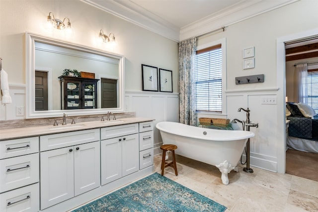 bathroom featuring ornamental molding, plenty of natural light, vanity, and a bathtub