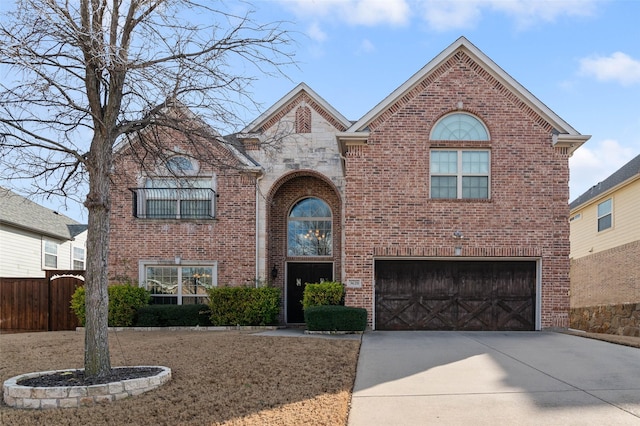 traditional home with fence, driveway, an attached garage, and brick siding