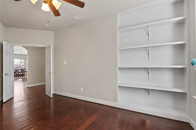 spare room with wood-type flooring, baseboards, arched walkways, visible vents, and a ceiling fan