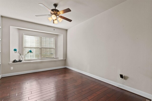spare room with baseboards, wood finished floors, and a ceiling fan