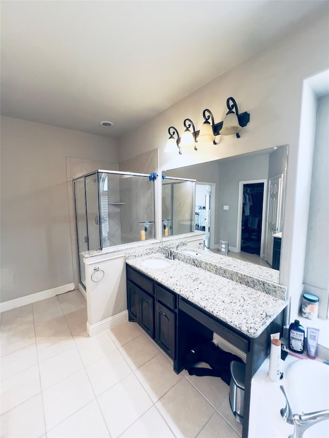 bathroom with tile patterned floors, vanity, baseboards, and a shower stall