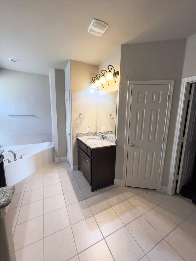 full bathroom with vanity, tile patterned flooring, a bath, baseboards, and visible vents