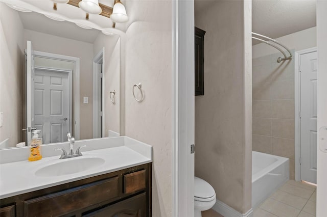 full bathroom featuring tile patterned flooring, vanity, tiled shower / bath, and toilet