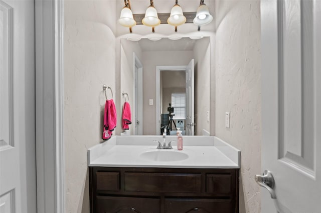 bathroom with a textured wall and vanity