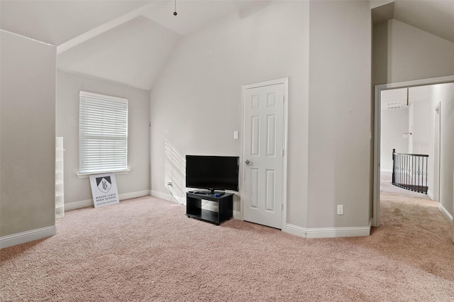 unfurnished living room featuring carpet floors, high vaulted ceiling, and baseboards